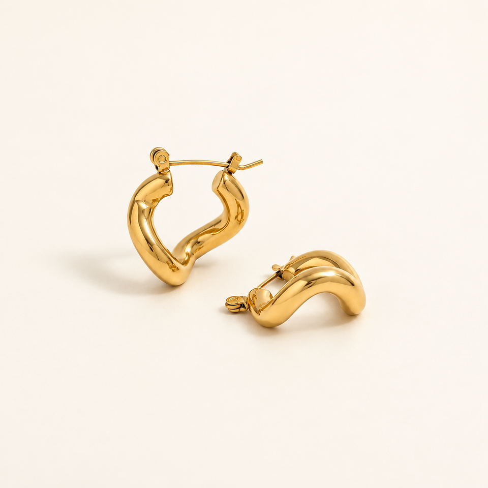 The Contour Hoops in gold plating on an ivory background