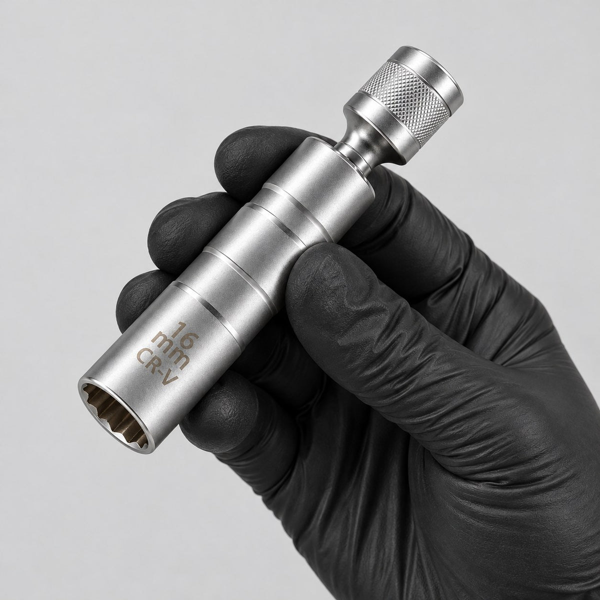 16 mm magnetic spark plug socket held in a gloved hand to show its size
