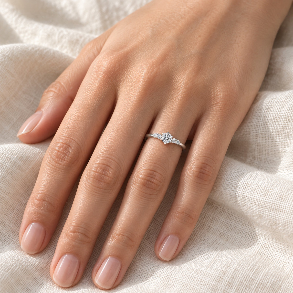 The Petite Moissanite Ring worn by a model in natural daylight