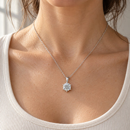 The Six-Prong Solitaire Necklace worn by a model in natural daylight