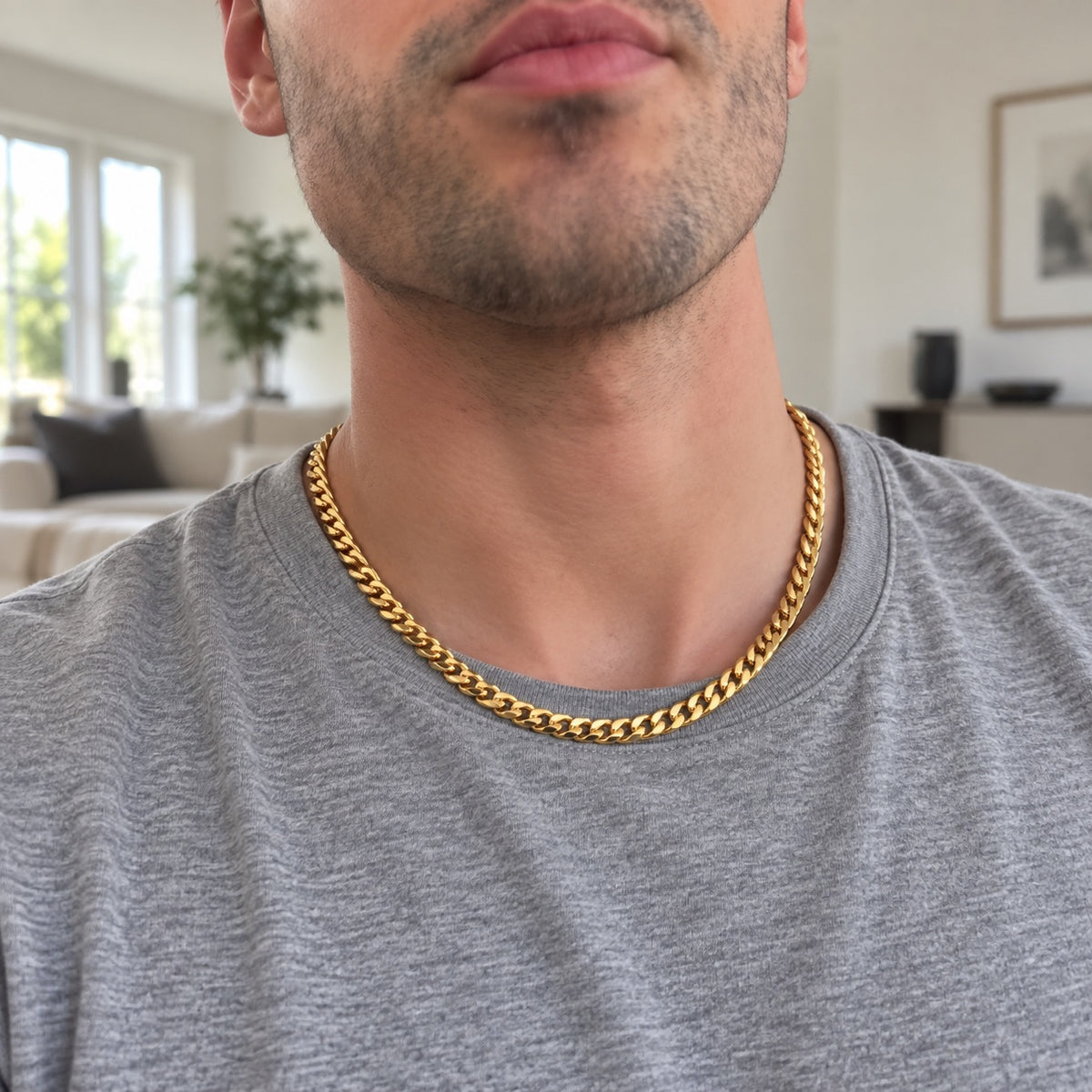 The Curb Chain in gold tone worn by a man over a grey t-shirt