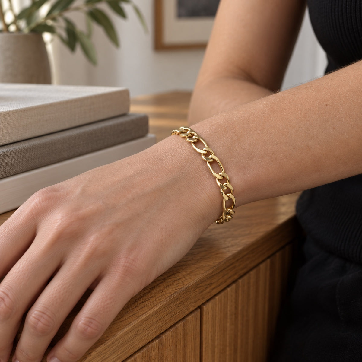 The Figaro Bracelet in gold tone worn on a woman's wrist