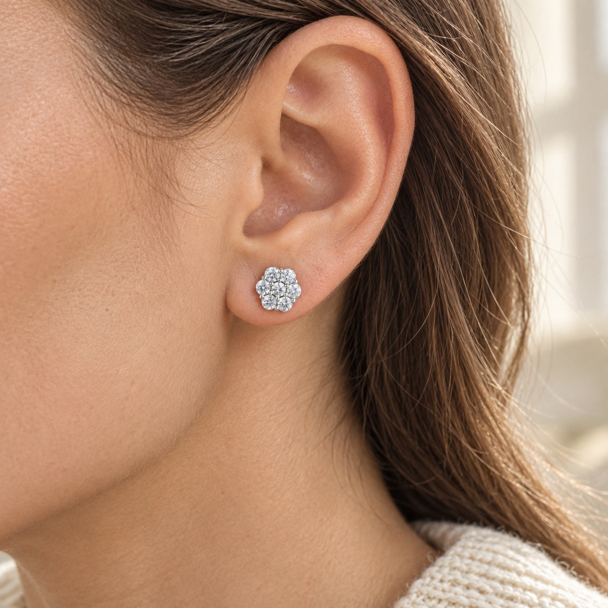 The Flower Moissanite Studs worn by a model in natural daylight, shown in the 7.5 mm size, white gold tone