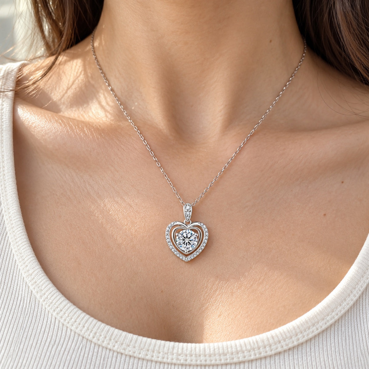 The Heart Moissanite Necklace worn by a model in natural daylight, shown with the 6.5 mm (1 ct) centre