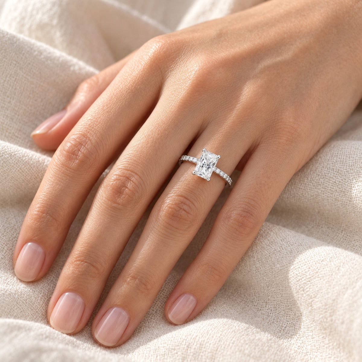 The Radiant Moissanite Ring worn by a model in natural daylight, 5 × 7 mm radiant centre stone