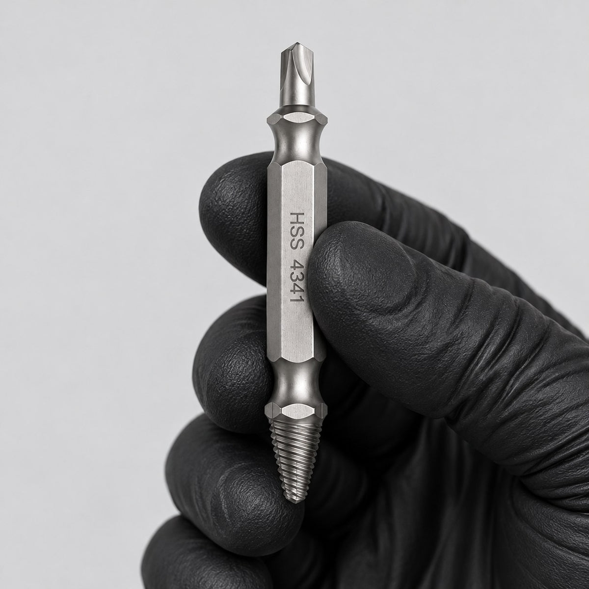 Screw extractor bit held in a gloved hand to show its size