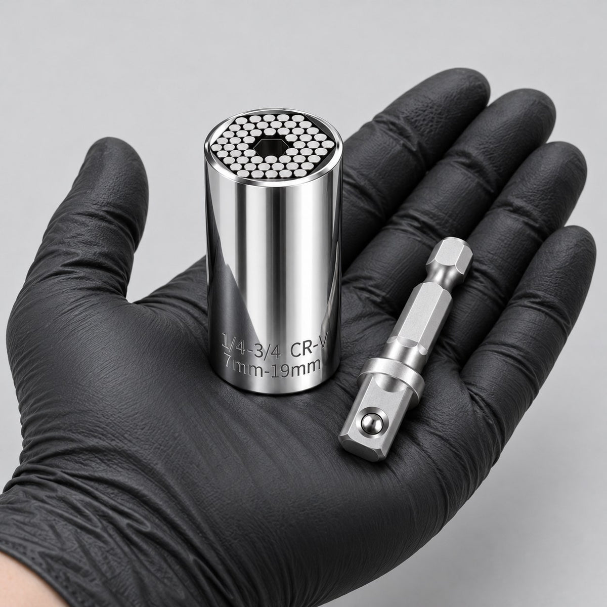 Universal socket with drill adapter held in a gloved hand to show its size